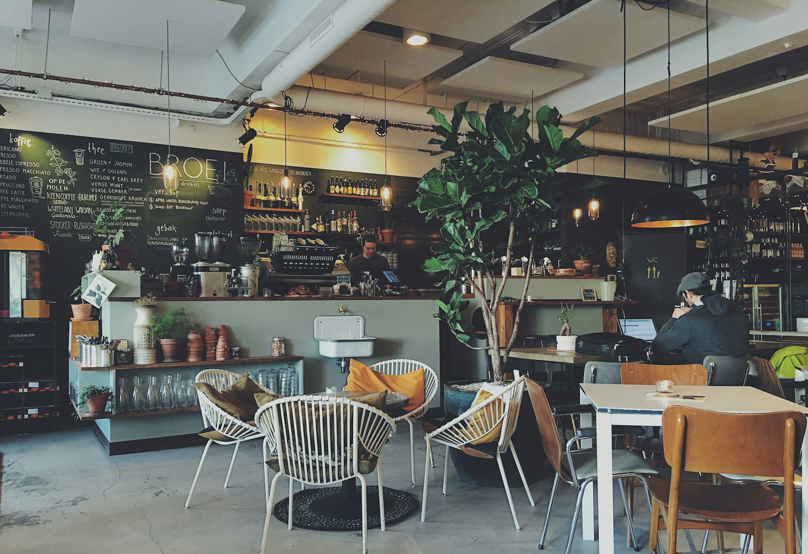 Cafe interior with a coffee counter, chalkboard menu and timber tables